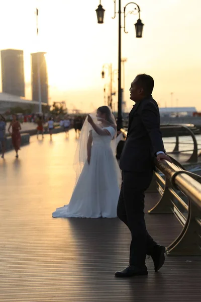 young bride and groom walking on the bridge