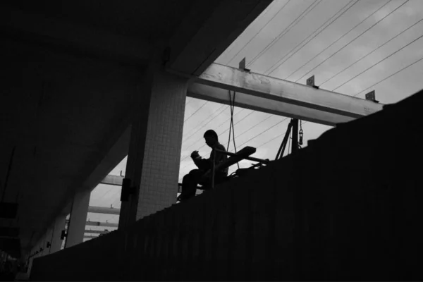 a man in a black suit with a large building of a construction site