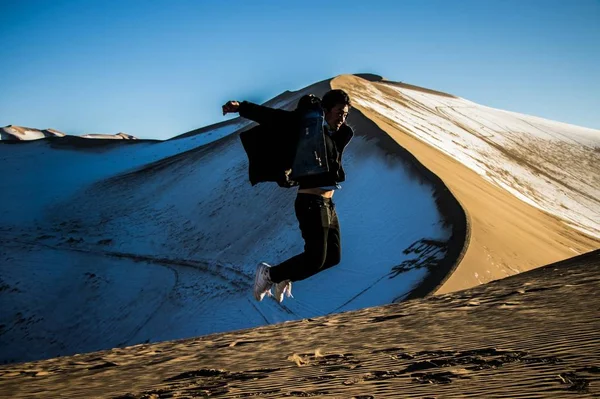 person jumping outdoor during Winter holiday at Gansu