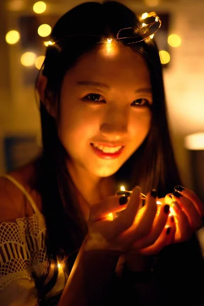 Cute asian girl with lights in room