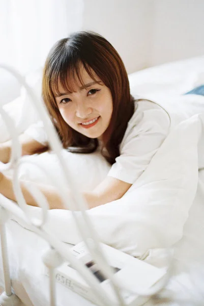 depositphotos 269267110 stock photo young asian woman lying bed девушка на кровати с телефоном