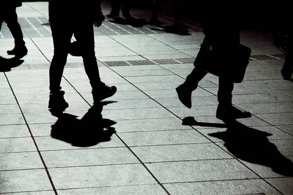silhouettes of people walking on the street