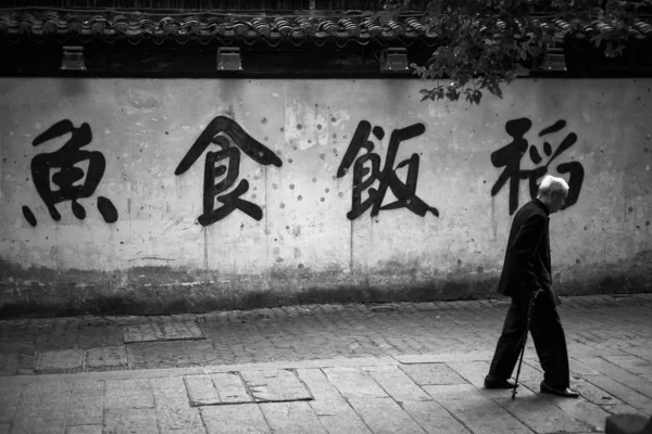 asian man in black and white clothing with a lantern