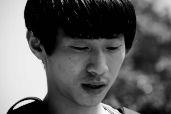 black and white portrait of young asian man at daytime