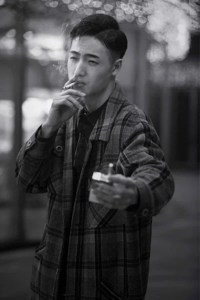 Black and white photo of young asian man in jacket