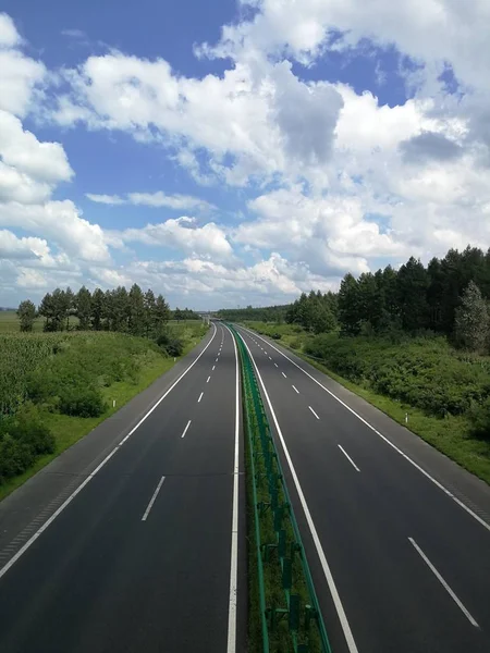 road with green sky and clouds