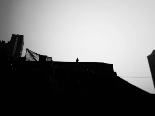 silhouette of a man and woman standing on the roof of the old building