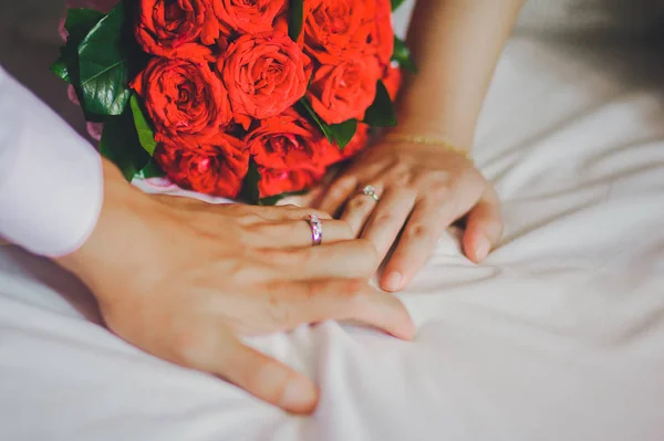 closeup view of married couple hands with bouquet