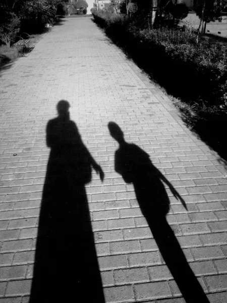 silhouette of a man and woman walking on the street