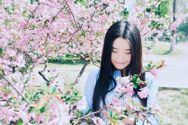 Ağaç Çiçekleri Dolu Bahçede Neşeli Asyalı Kadın — Stok fotoğraf