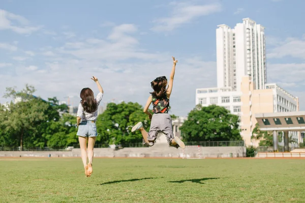 two girls jumping in the park