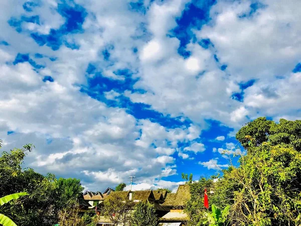 stock image green and blue sky with clouds