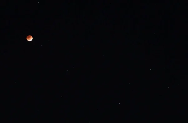 black night sky and orange moon