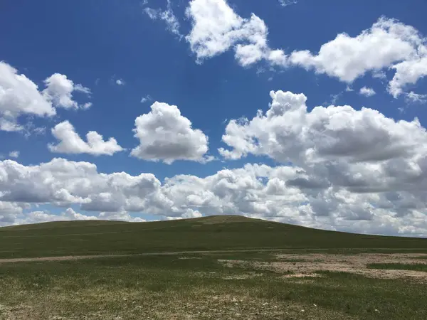 stock image green field and blue sky with clouds