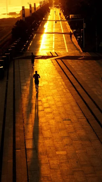 Silueta Hombre Caminando Por Calle Con Una Puesta Sol — Foto de Stock