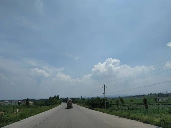 road and blue sky with clouds