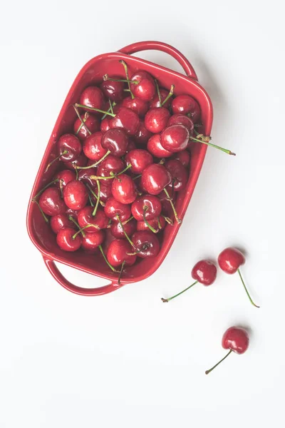 fresh red cherry in a white bowl on a light background