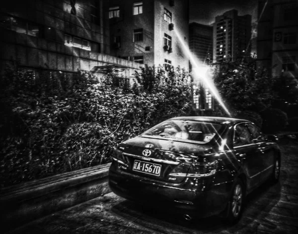black and white photo of a car in the city