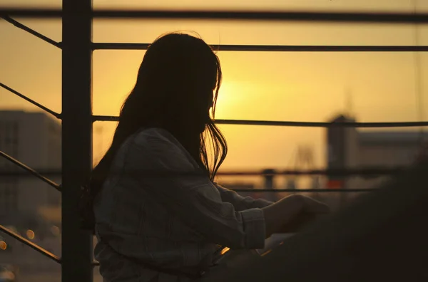 Günbatımının Arka Planında Sırt Çantası Olan Ceketli Genç Bir Kadın — Stok fotoğraf