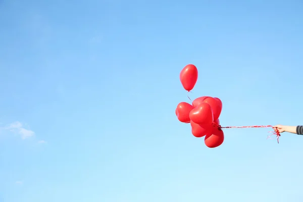 heart shaped balloons on a blue sky background