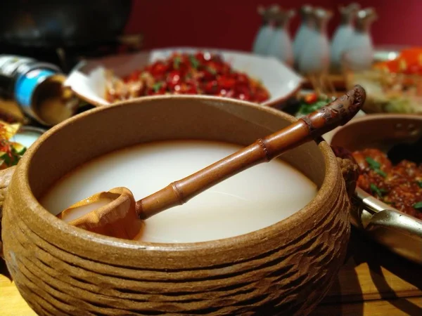 wooden mortar and pestle with a red pepper and a spoon