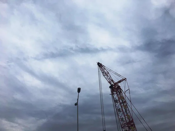 construction crane and building site against sky