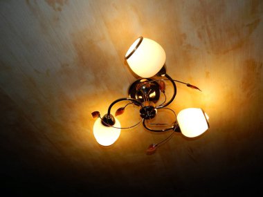 Chandelier is lit in the interior of the apartment