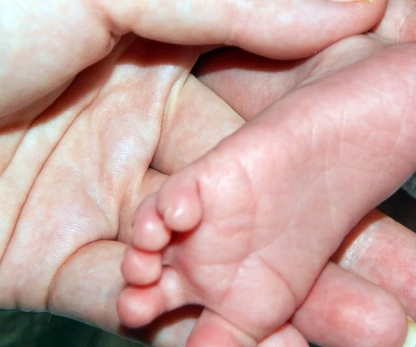 Annenin Eli Bir Bebeğin Ayağını Tutuyor — Stok fotoğraf