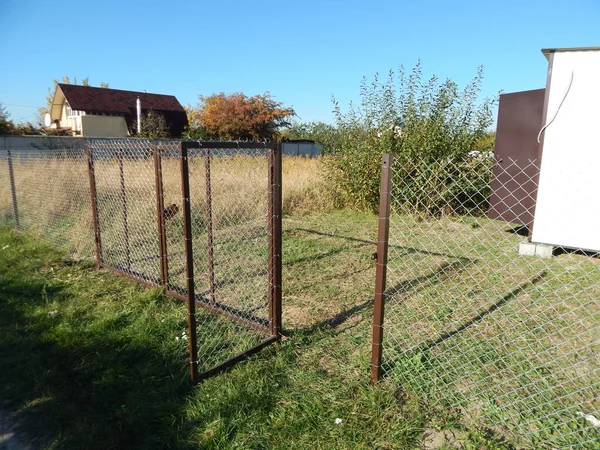 Arazi arsa üzerinde bir zincir bağlantı kılavuzundan bir çit inşaatı