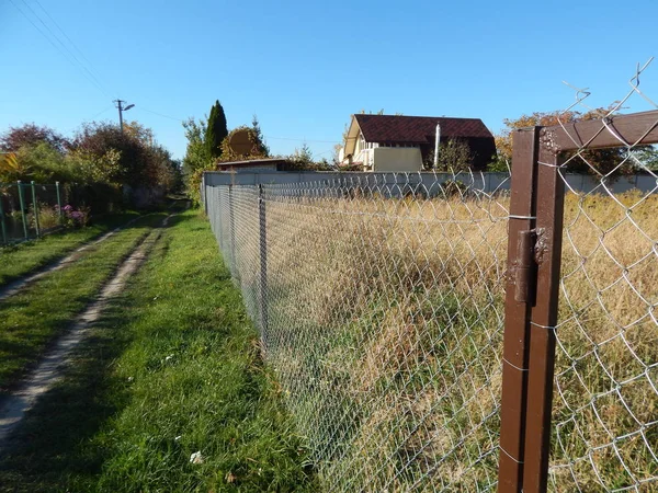 Arazi arsa üzerinde bir zincir bağlantı kılavuzundan bir çit inşaatı