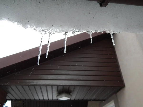 冬天的冰柱挂在楼顶 — 图库照片
