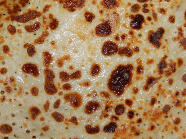 Pancakes on a new cast-iron skillet on Shrovetide — Stock Photo, Image