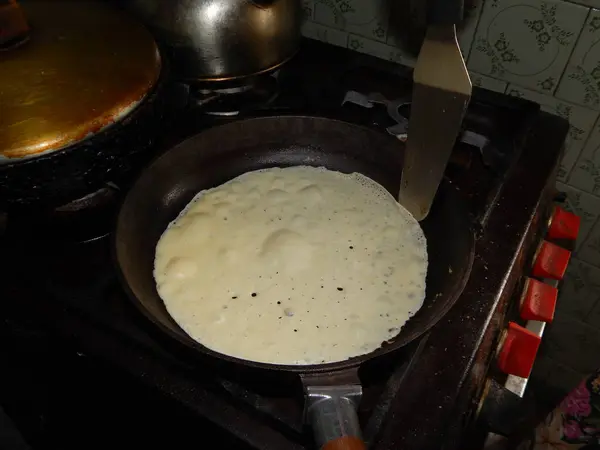 Pancakes on a new cast-iron skillet on Shrovetide — Stock Photo, Image