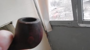 Evin balkonunda gerçek tütünle pipo içiyorum.