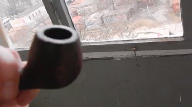 Evin balkonunda gerçek tütünle pipo içiyorum.