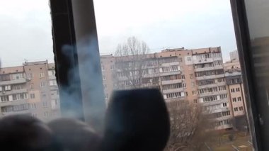 Evin balkonunda gerçek tütünle pipo içiyorum.