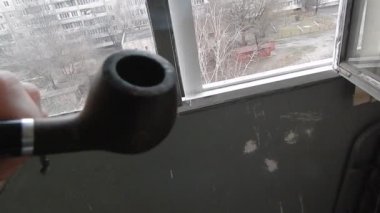 Evin balkonunda gerçek tütünle pipo içiyorum.