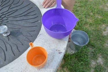 Bir kova bahçesinde sulama bitkileri bir kuyudan su ile