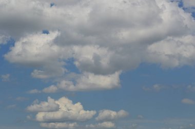 Mavi gökyüzü arka planı üzerinde büyük beyaz bulutlar