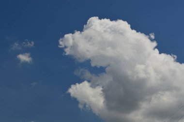 Mavi gökyüzü arka planı üzerinde büyük beyaz bulutlar