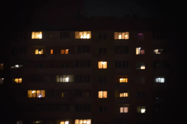 Panorama de janelas noturnas de edifícios de vários andares na cidade — Fotografia de Stock