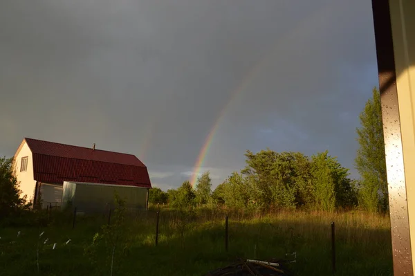 Rainbow over the village after a thunderstorm and the rain