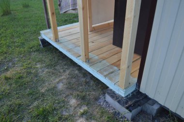 Raflardan ve kirişlerden oluşan verandanın girişinin inşaatı