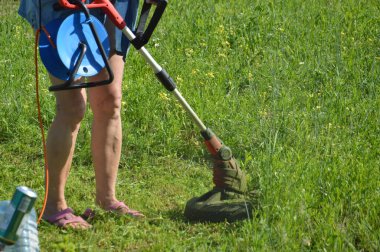 Çim biçme makinesinde bir kadınla çim biçmek.
