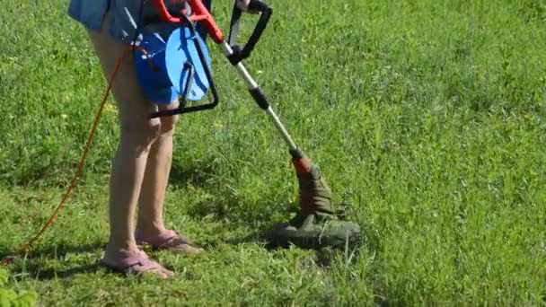 草や草を刈る女性トリマー — ストック動画