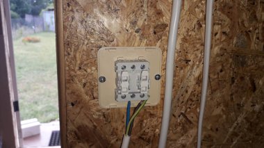 Evin içinde elektrik kabloları, prizler ve lambalar var.