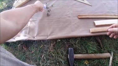 Kapıyı kumaşla örtmek için küçük çiviler çakıyorum.