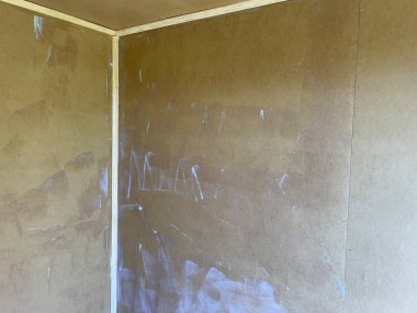 Tahta duvar yüzeyine görünür fırça darbeleriyle koruyucu vernik kaplama uygulaması.