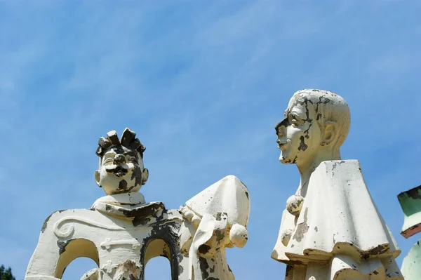 Old abandoned sculptures of clowns with peeling paint. — Stock Photo, Image