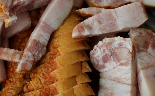 Cutting sausage and cured meat on a celebratory table.